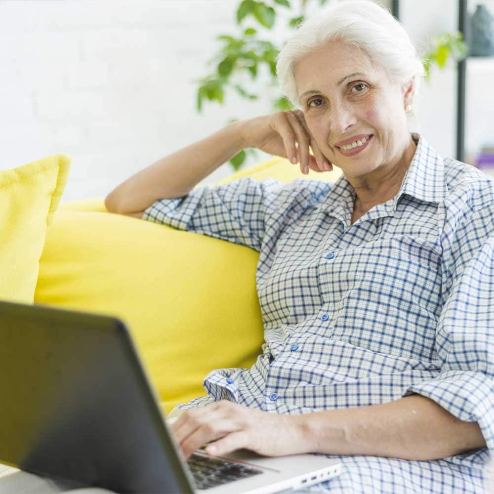 Une femme senior qui surfe sur les sites de rencontre pour seniors sur Internet