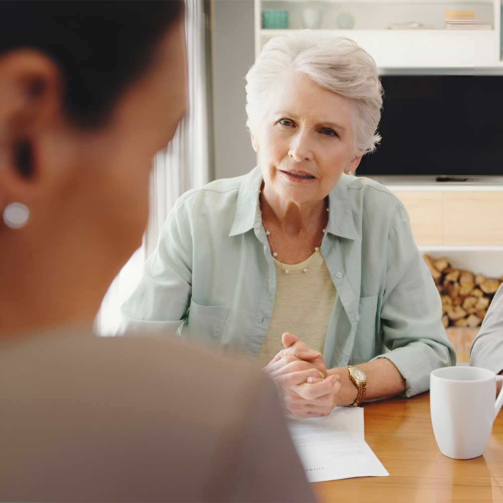 Une femme senior échange avec Madame le Juge pour la mise sous curatelle aménagée de sa sœur