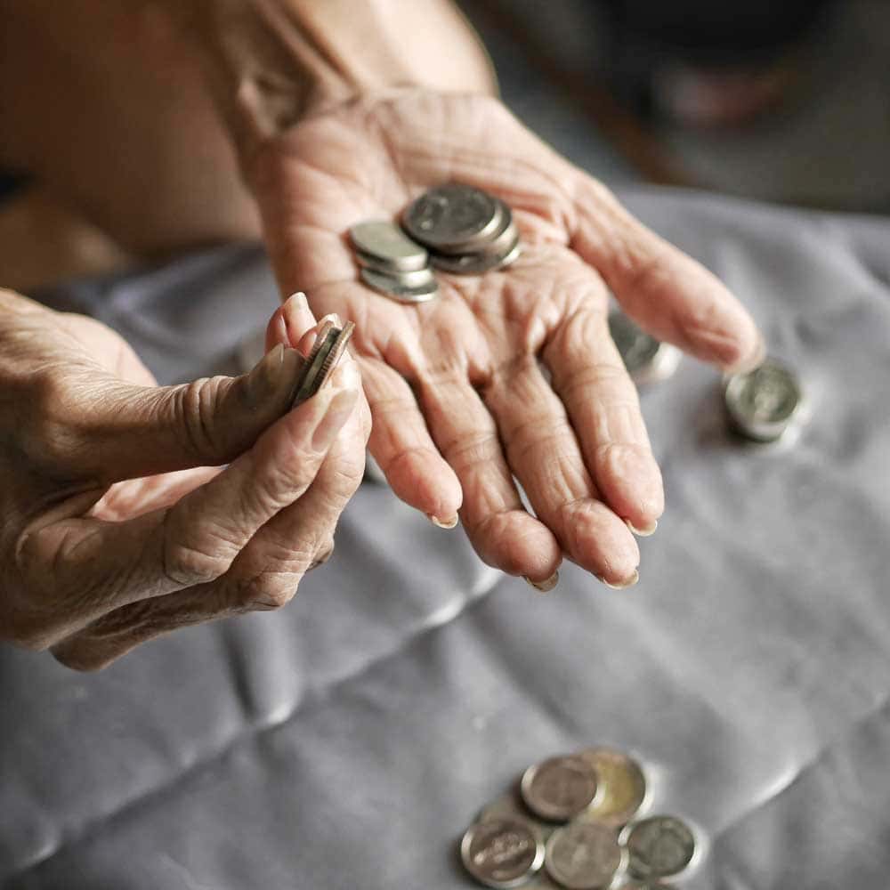 Une vieille dame compte l'argent des aides financières reçues pour la téléassistance