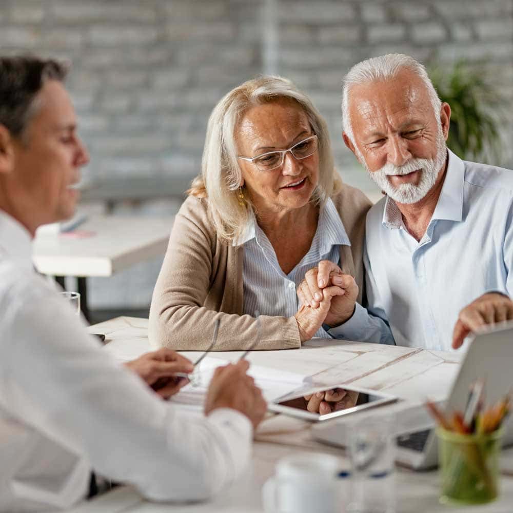 Un homme et une femme seniors se renseigne auprès de leur conseiller pour une prise en charge de la mutuelle sur la téléassistance