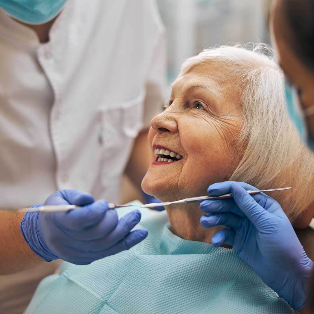 Une femme senior se fait soigner les dents par un dentiste à domicile