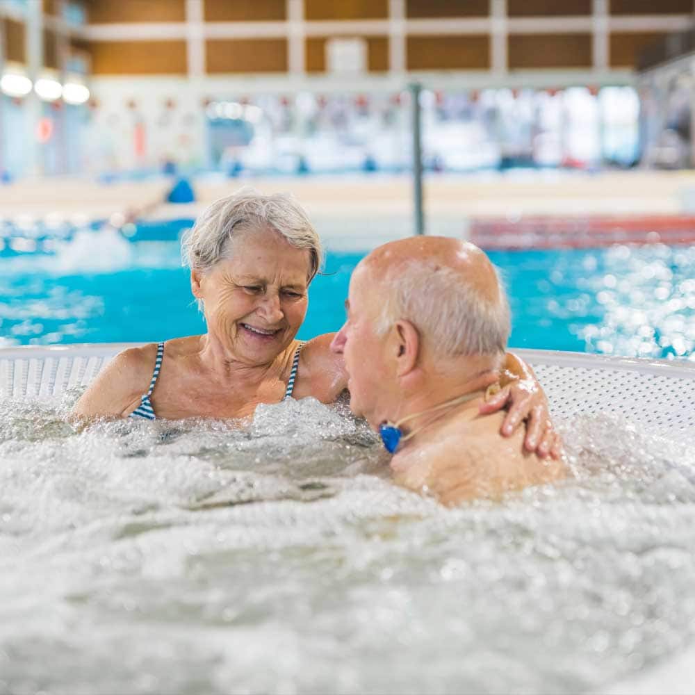 Un couple de seniors profite des bienfaits de l'eau sur leur santé dans un SPA.